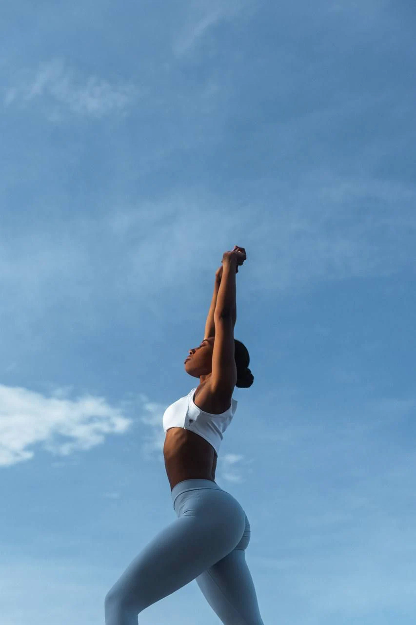 Woman training with light dumbbells in bright studio